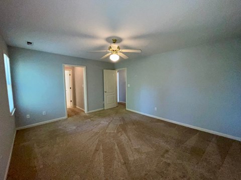 a living room with blue walls and a ceiling fan