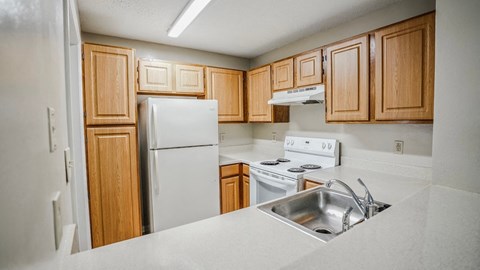 a kitchen with white appliances and wooden cabinets