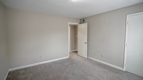 an empty living room with a door to a hallway