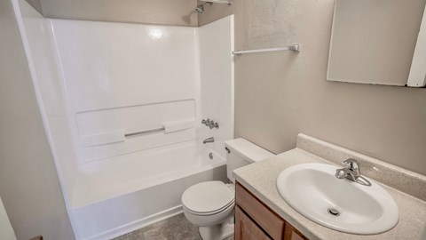an empty bathroom with a sink toilet and shower