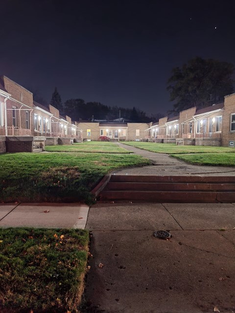 A long building with a lot of windows is lit up at night.