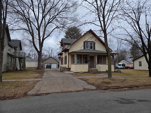 A house with a brown roof and a white porch.