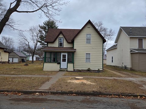 a yellow house with a yard in front of it