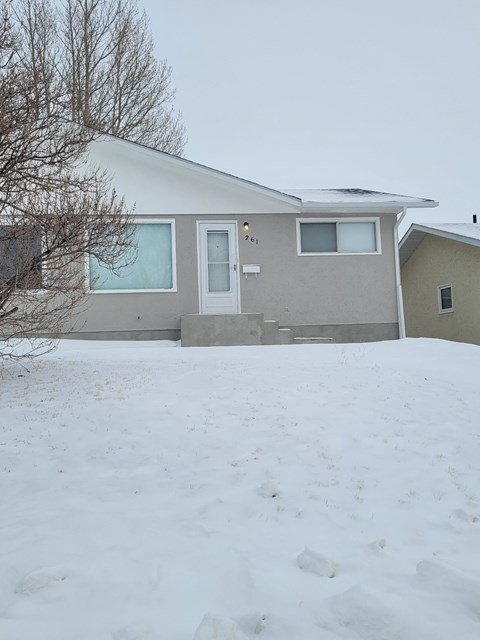 the front of a house with snow in front of it