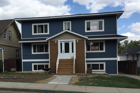 a blue house with a white door and wooden steps