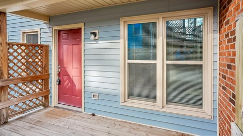 a blue house with a red door and a porch