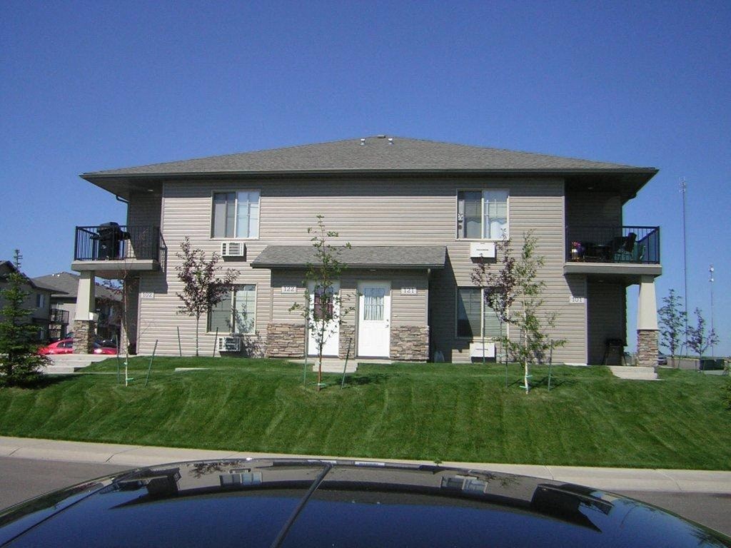 a house with a yard and a car parked in front of it