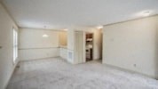 an empty living room and kitchen with no furniture