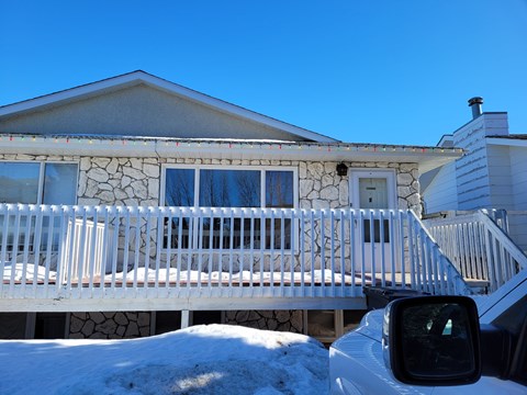 a house with a white fence in front of it in the snow