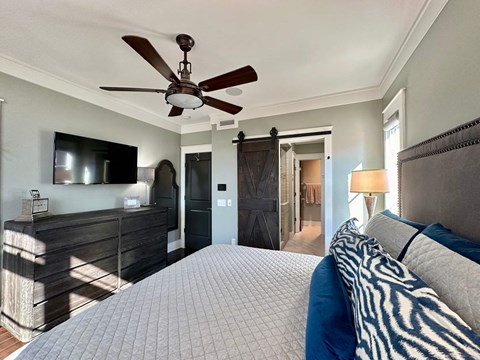 a bedroom with a large bed and a ceiling fan