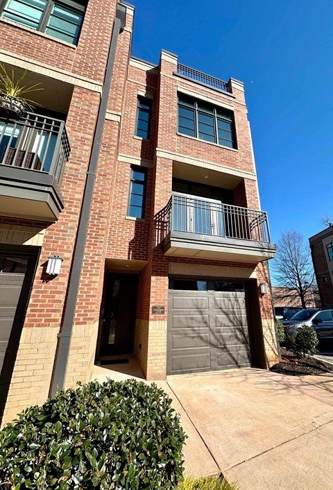 a brick building with two garage doors and a balcony