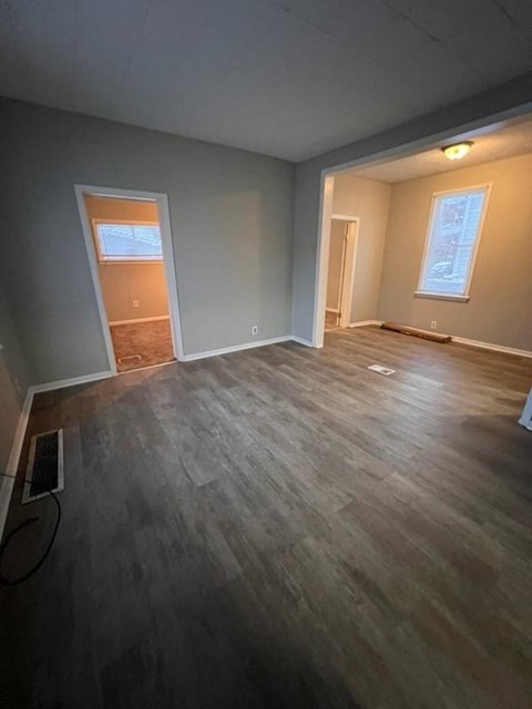 an empty living room with a hard wood floor