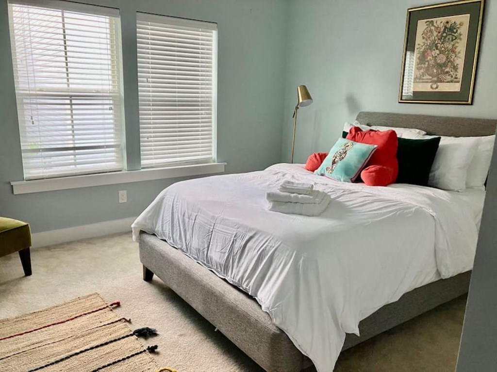 a bedroom with a bed and two windows