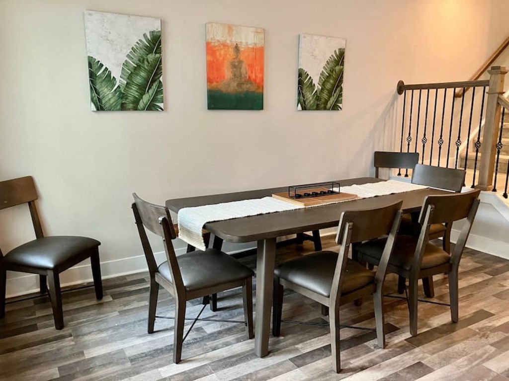 a dining room with a table and chairs and paintings on the wall