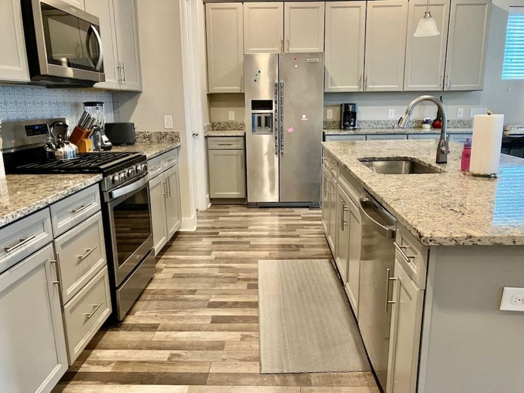 a kitchen with stainless steel appliances and marble counter tops
