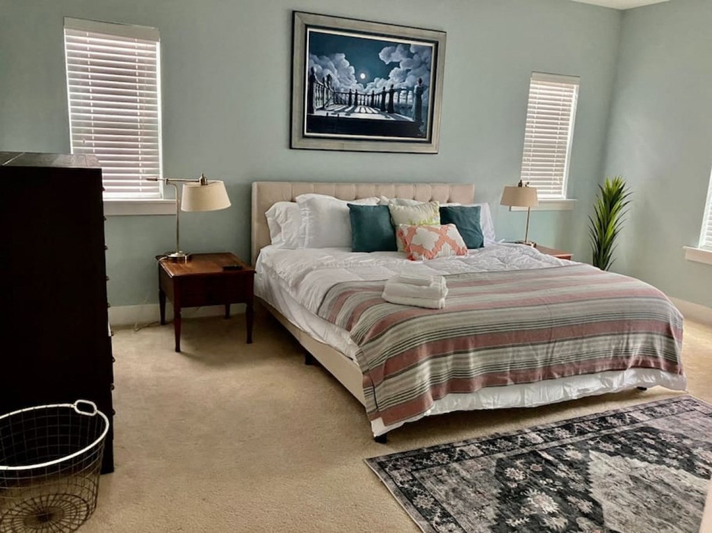 a bedroom with a bed and a painting on the wall