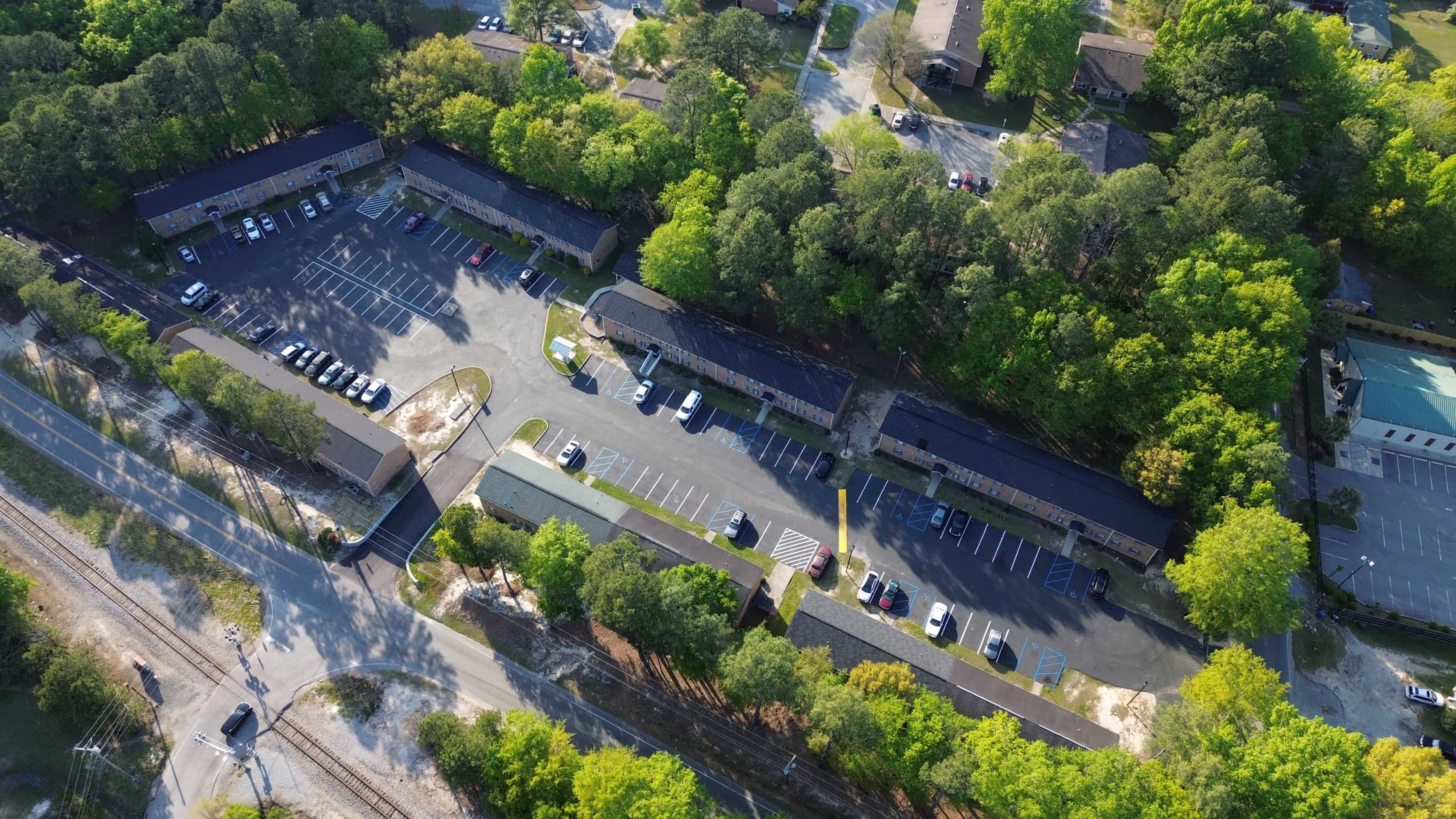 an aerial view of a parking lot with cars and trees