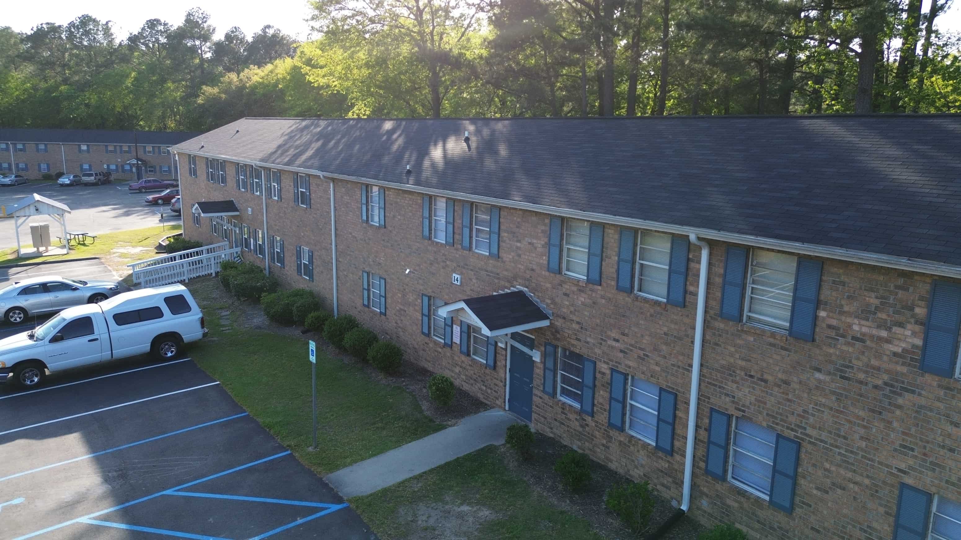 an aerial view of a brick building with a parking lot