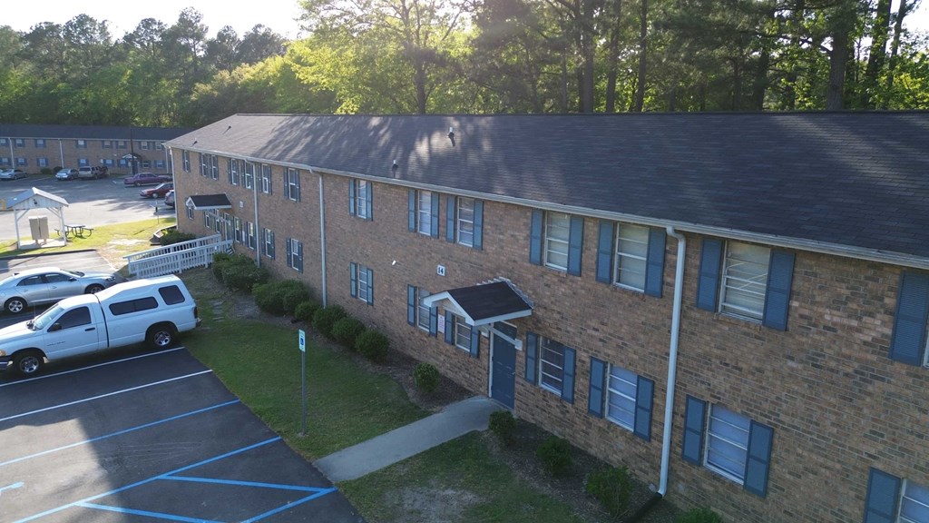 an aerial view of a brick building with a parking lot