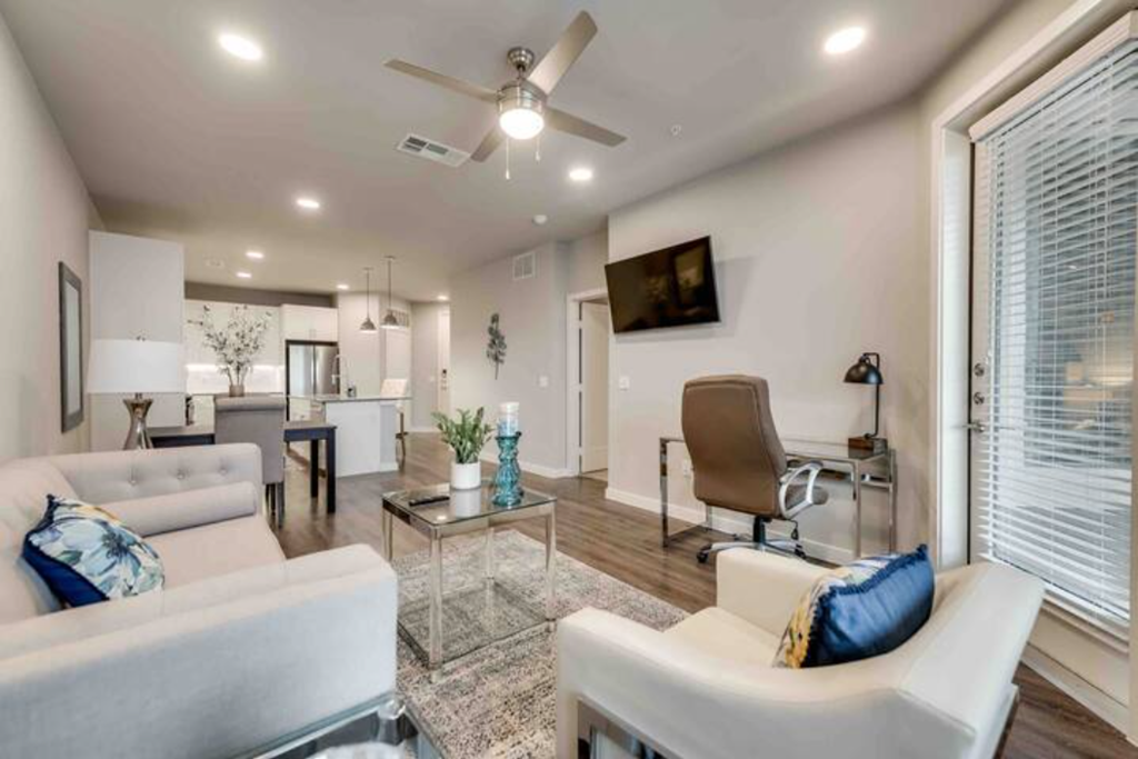 a living room with furniture and a ceiling fan