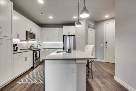 a white kitchen with an island in the middle