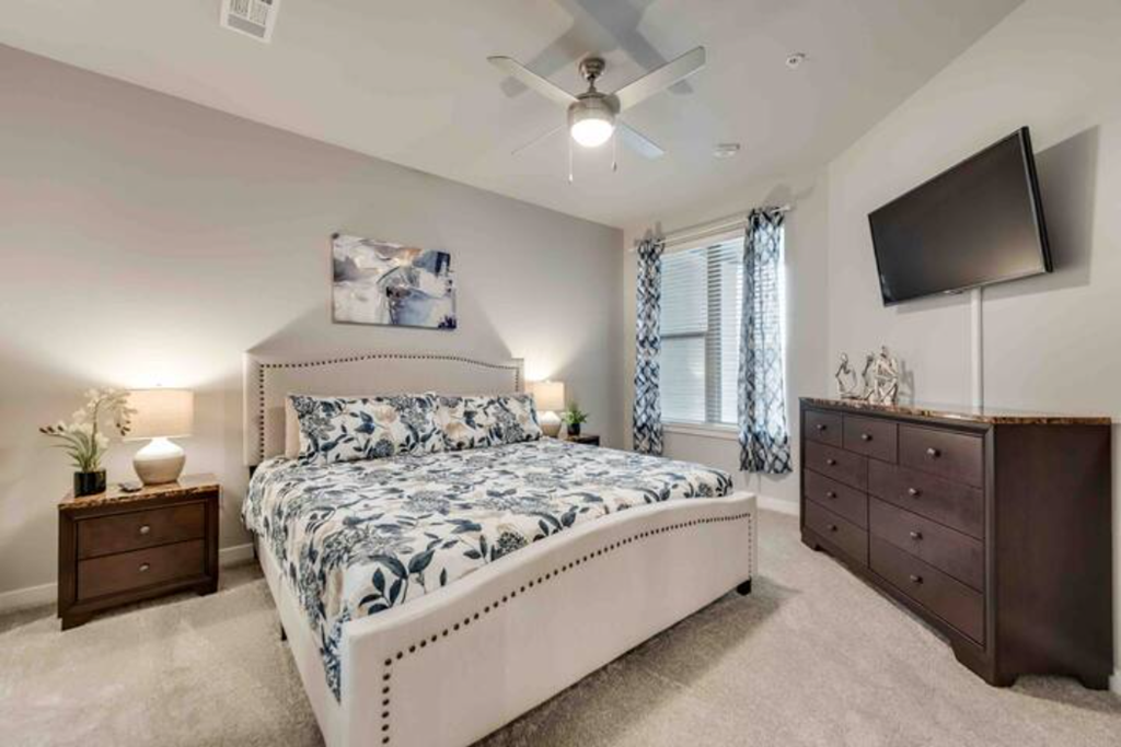 a bedroom with a bed and a ceiling fan