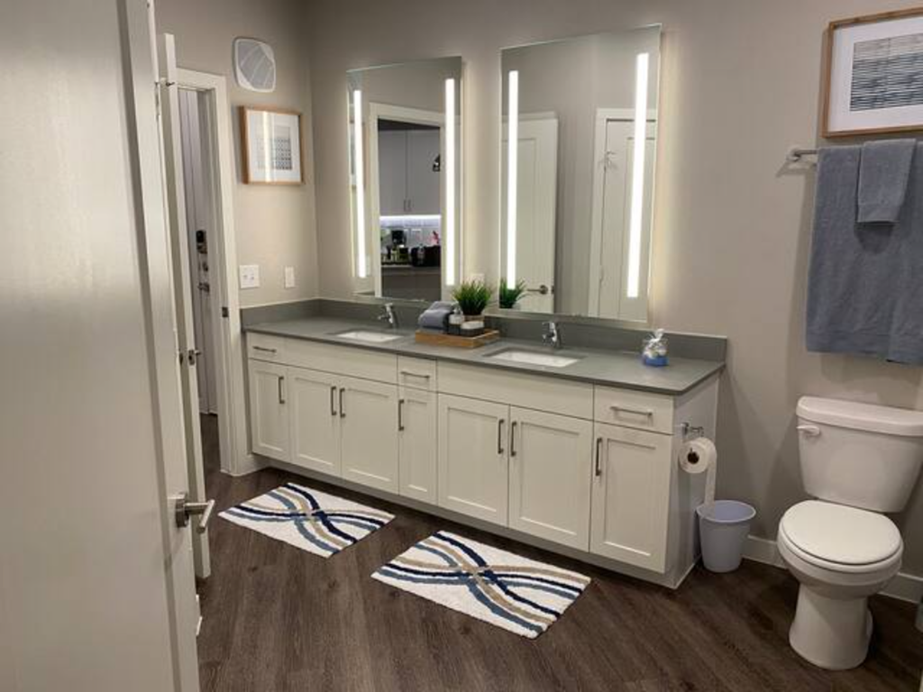 a bathroom with a toilet and a sink and mirrors