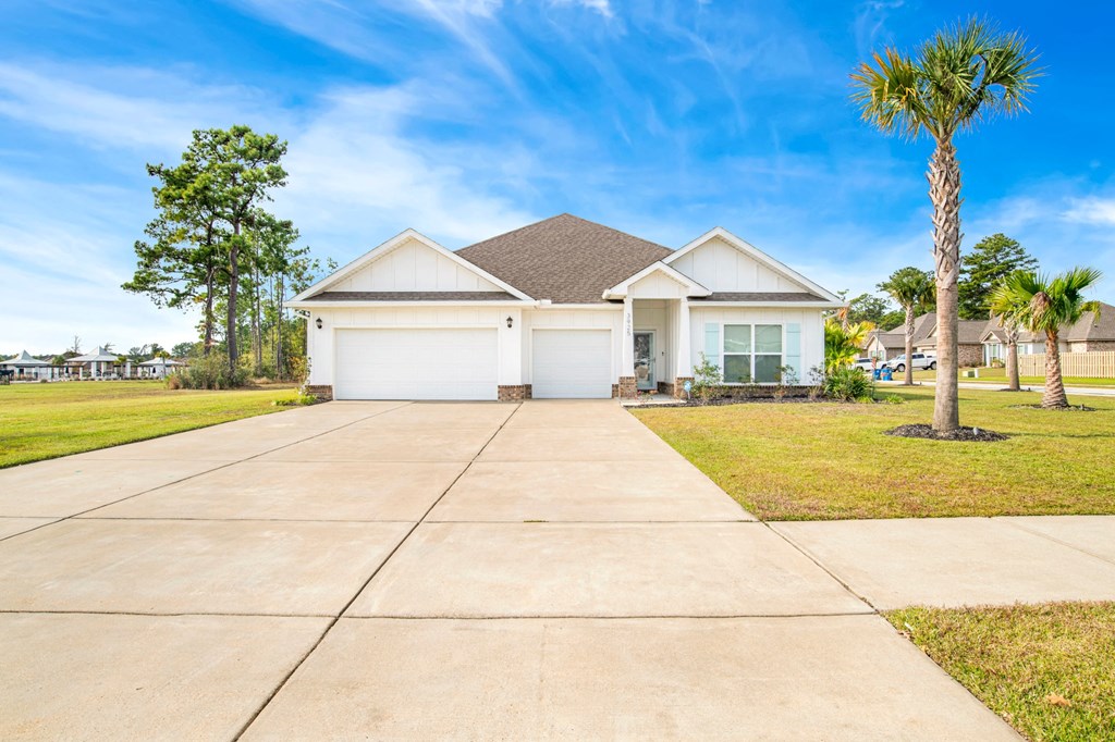a house with a driveway and a palm tree
