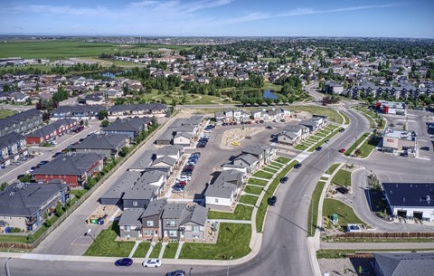 an aerial view of a neighborhood of houses and cars on a road