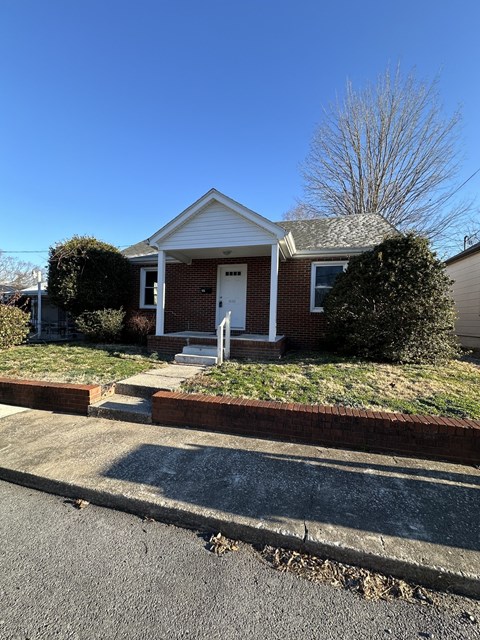a small brick house with a white front door