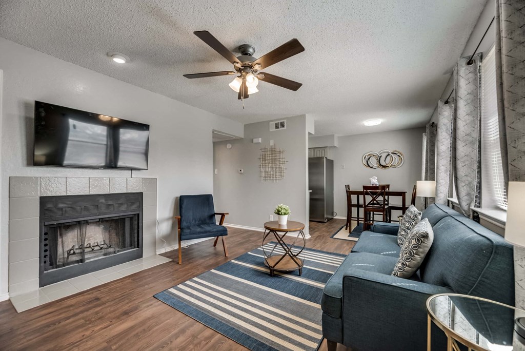 a living room with a fireplace and a ceiling fan