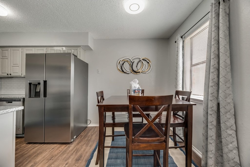 a kitchen with a table and chairs and a refrigerator
