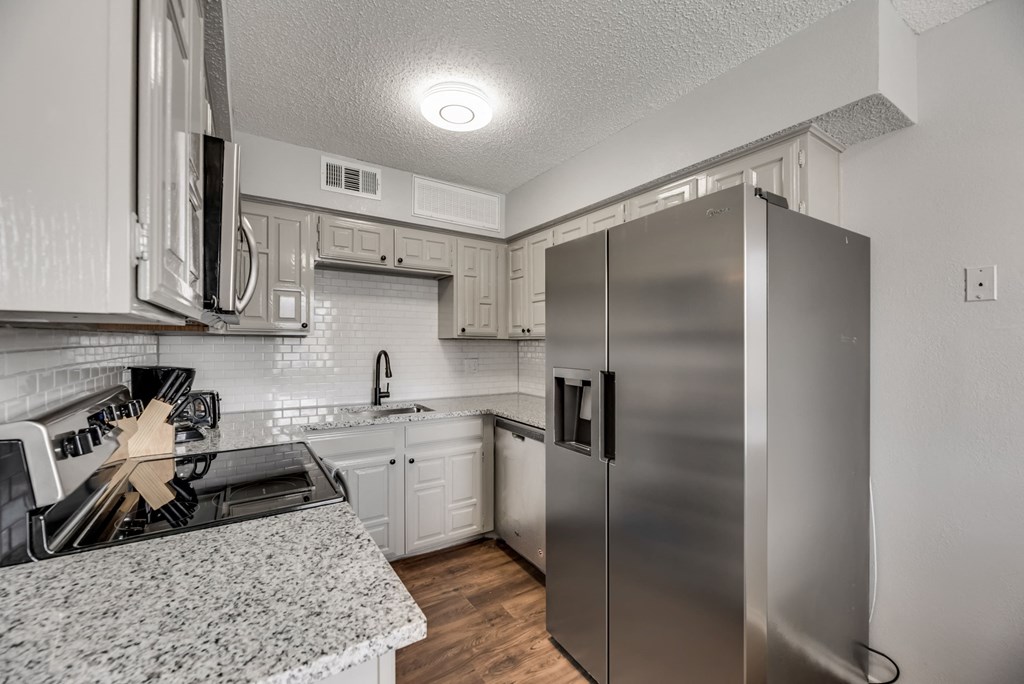 an updated kitchen with stainless steel appliances and granite counter tops