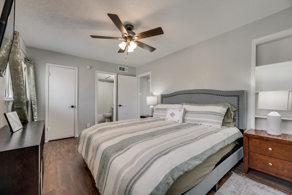 a bedroom with a bed and a ceiling fan