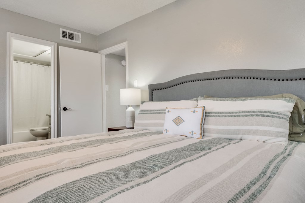 a bedroom with a bed and a bathroom with a toilet