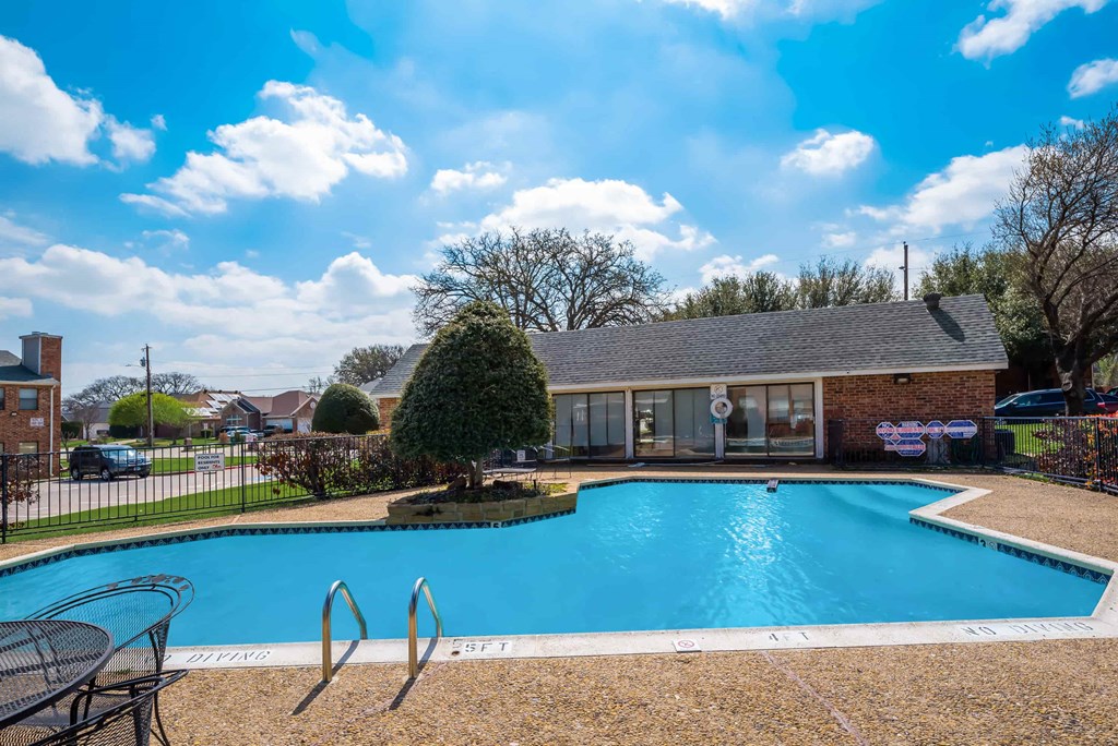 a swimming pool with a house in the background