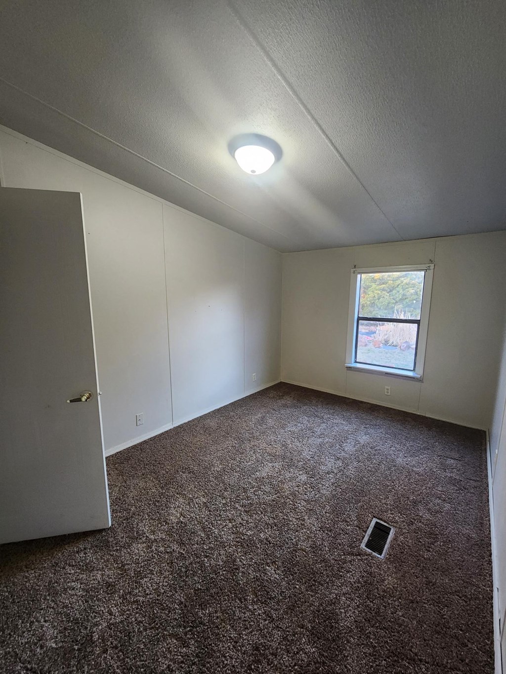 a room with carpet and a window and a door