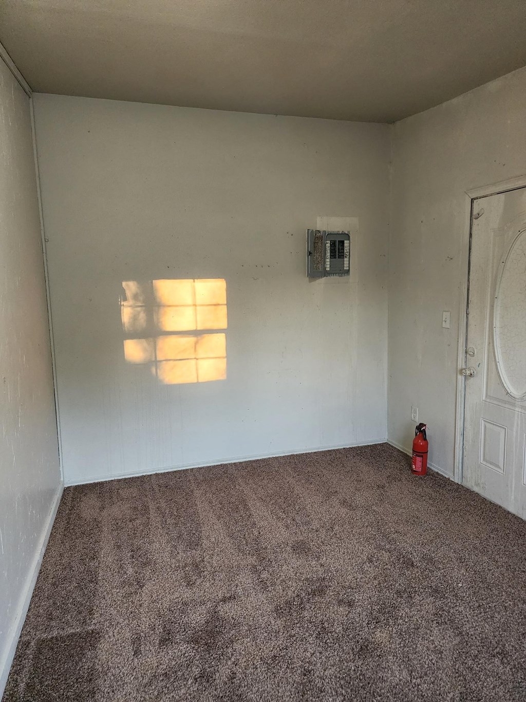 a small room with carpet and a door