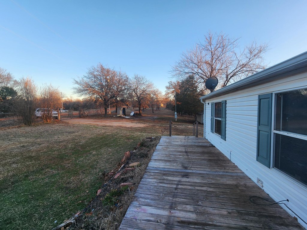 a view of the side of a house with a wooden walkway