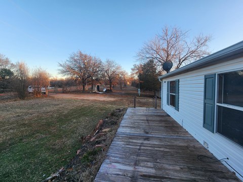 a view of the side of a house with a wooden walkway