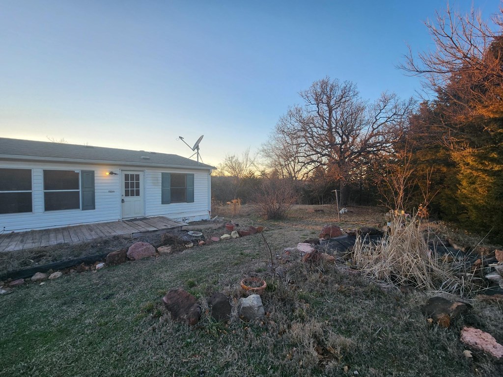 a small white house with a yard and a wind turbine