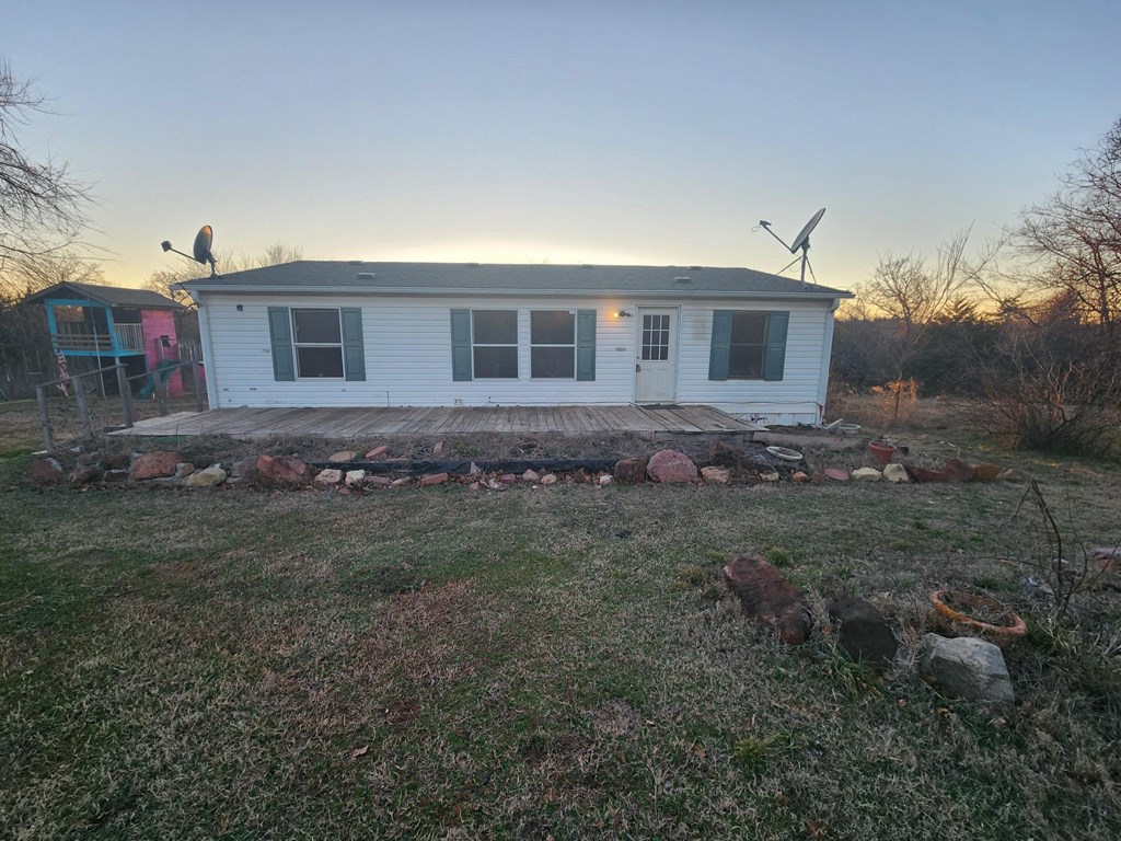 a small white house with a wooden deck in front of it