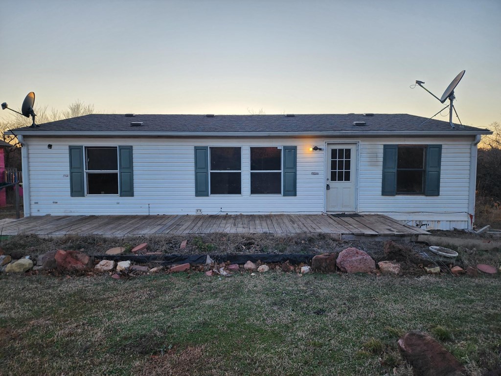 a small white house with a porch and a deck