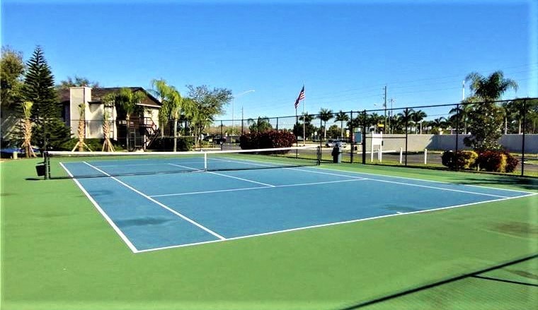a blue and green tennis court with a flag