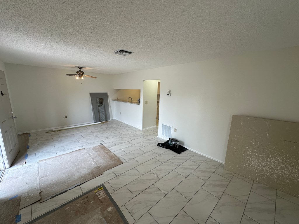 a living room with a tile floor and a ceiling fan