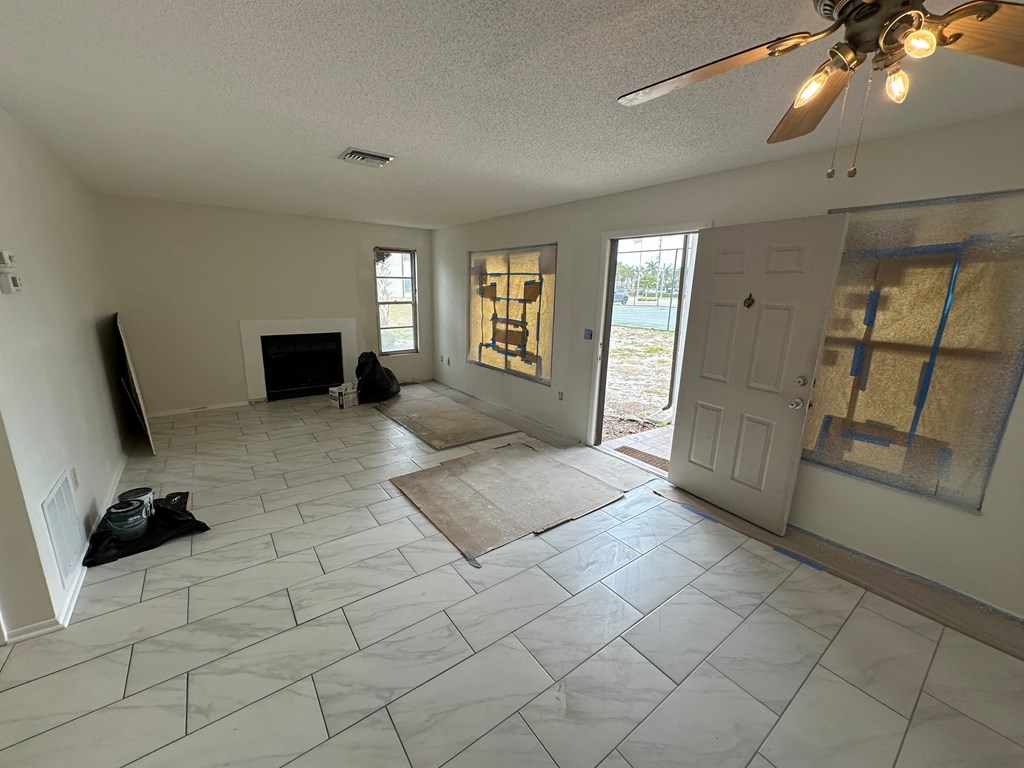 a living room with a tile floor and a ceiling fan