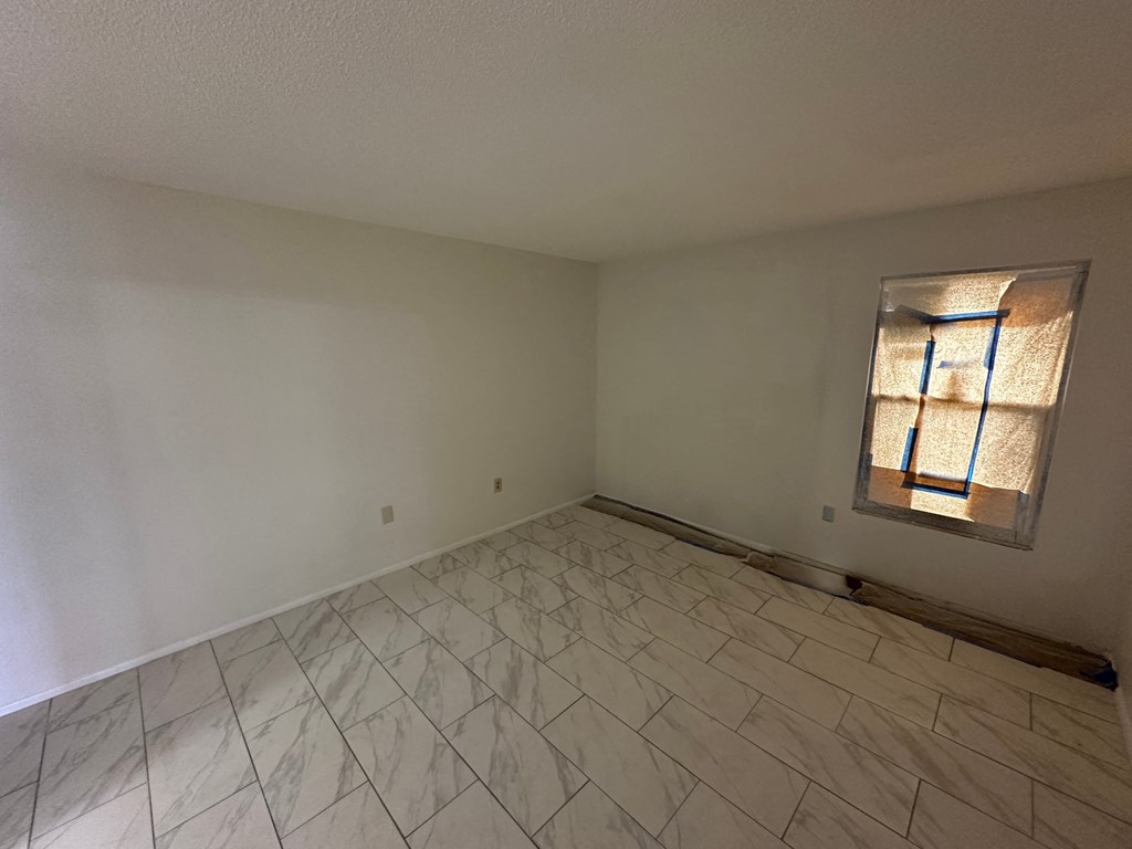 the living room has a tile floor and a window