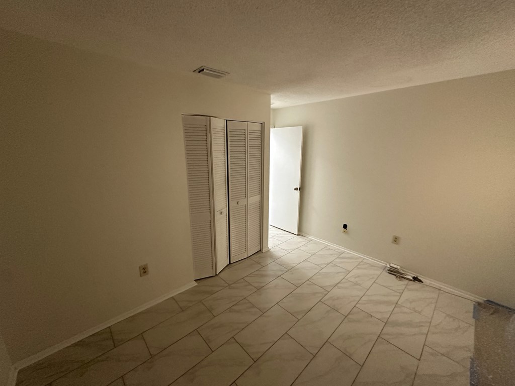 an empty room with a closet and a tiled floor