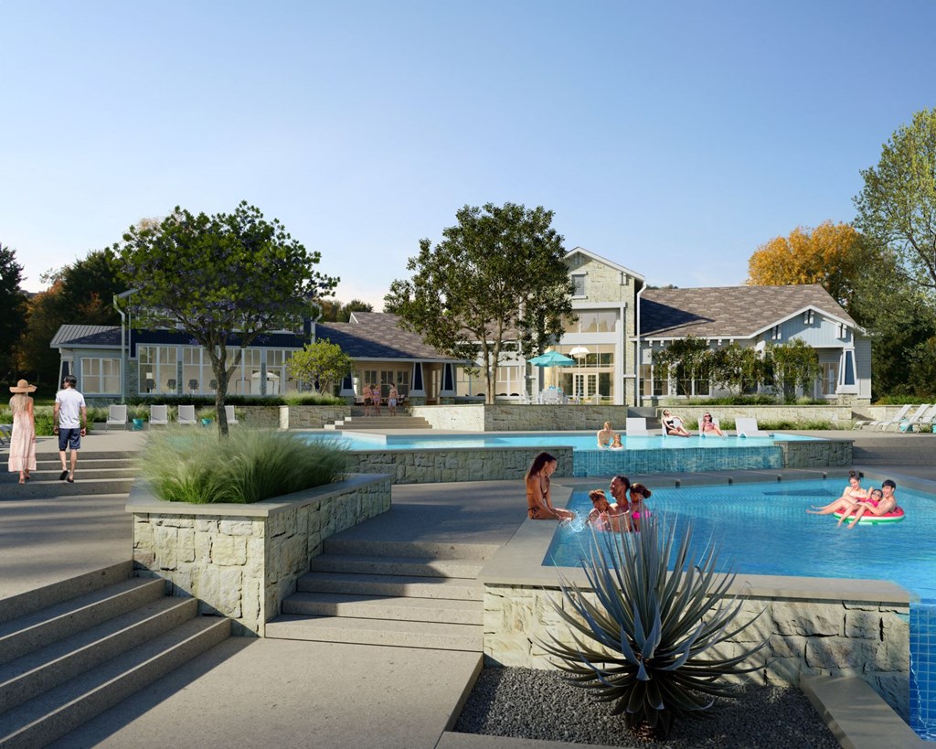 people in a swimming pool at a resort with houses in the background