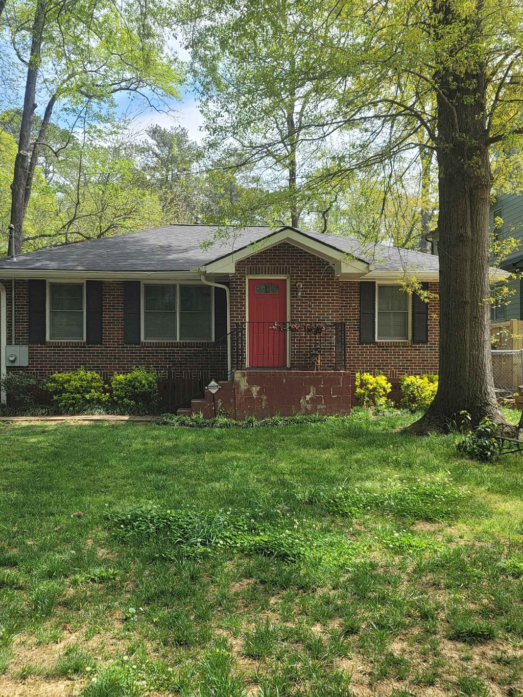 a small brick house with a red door